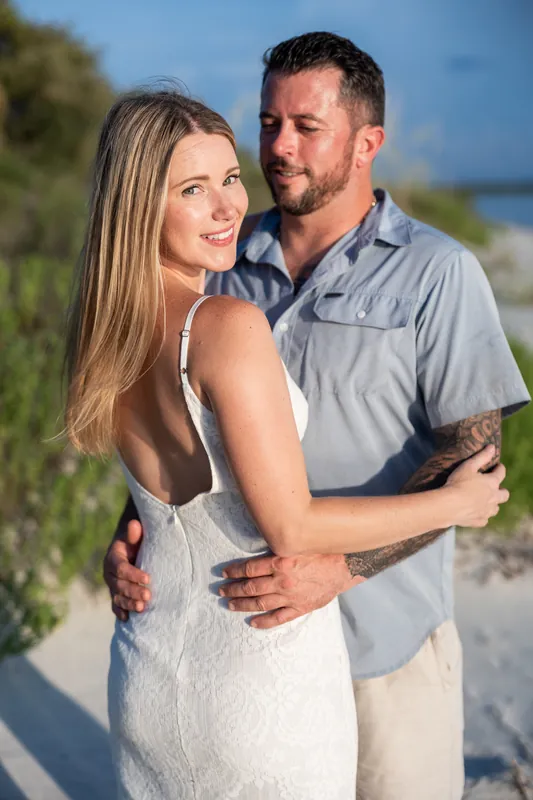 Jenna and Russell sit together on a boat at Matanzas Inlet, smiling as Russell points toward the water under a cloudy sky.