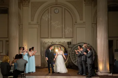Couple grand entrance through vault door at Treasury on the Plaza