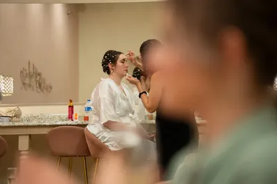 Bride getting makeup done before Treasury on the Plaza wedding