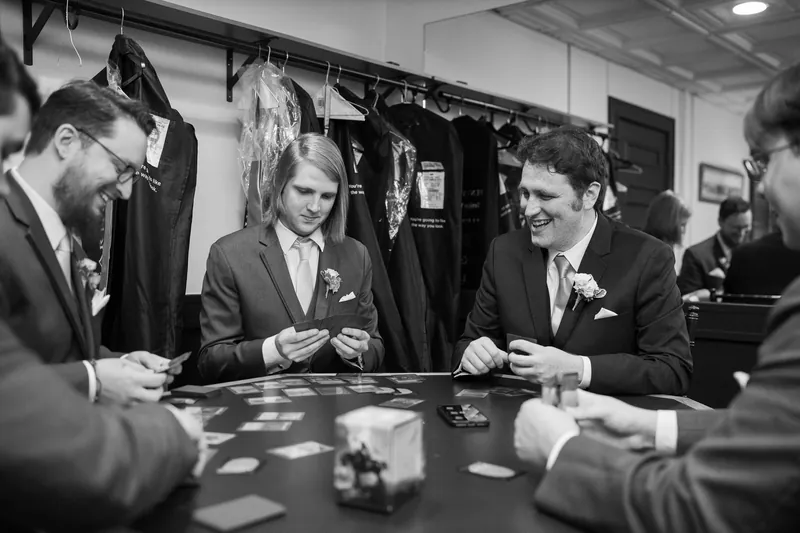 Groomsmen playing cards before wedding ceremony