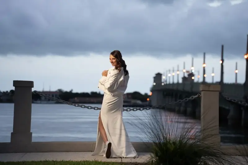 Bride posing near waterfront bridge