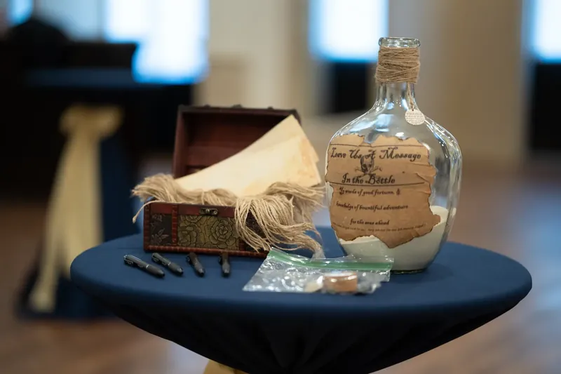 A labeled glass bottle and decorative box sit on a round black table at The Treasury on the Plaza.