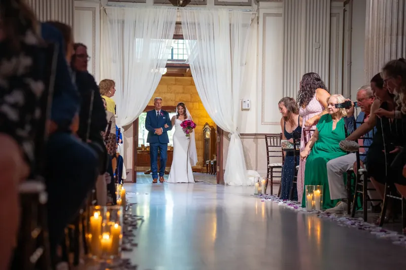 Jessica and John exchange vows at the altar as guests watch from both sides at The Treasury on the Plaza.