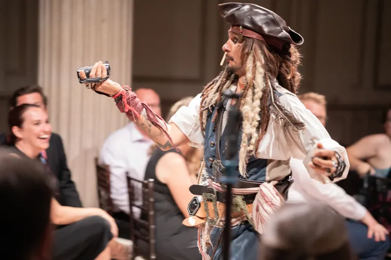 A costumed pirate character dances and gestures mid-performance during the wedding reception entertainment.