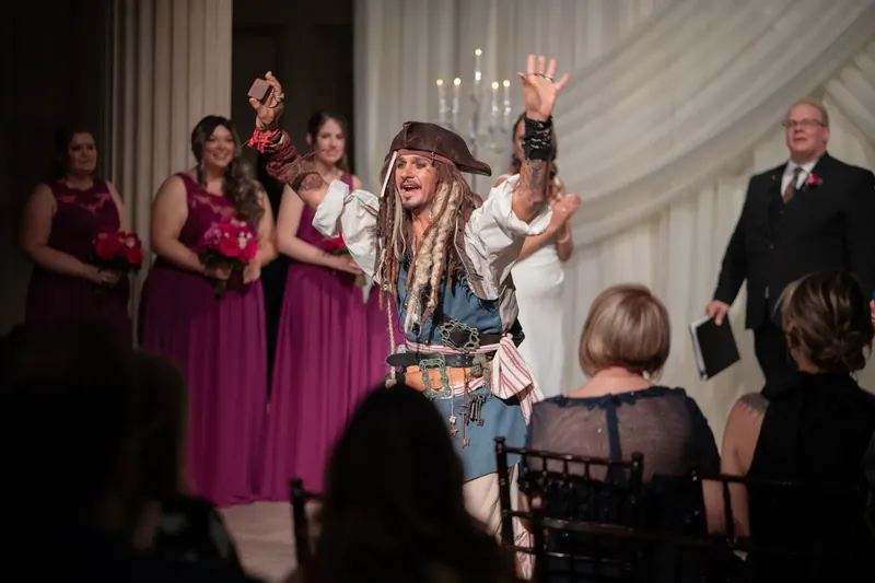 Jessica raises her arms while performing at The Treasury on the Plaza, flanked by attendants in magenta and dark suits.