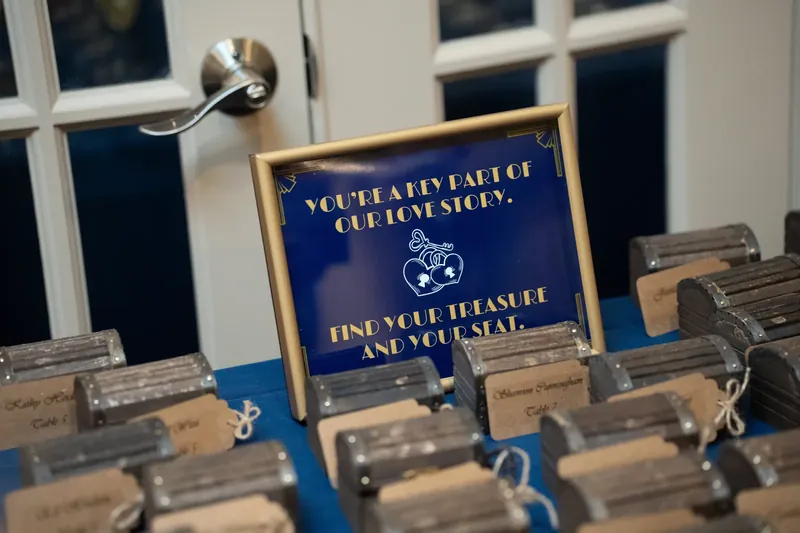A blue and gold table card reads "You have perfect love story. Use wisely and you're set" with wooden place card holders.