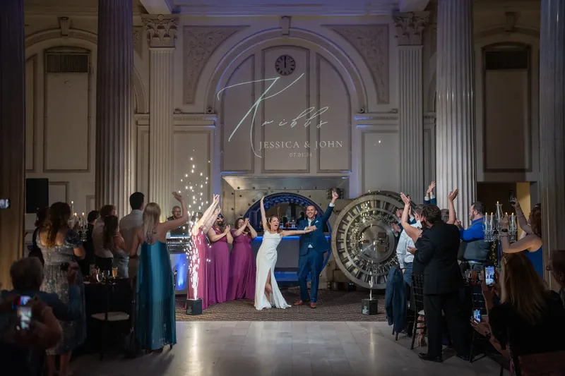 Jessica and John stand under an archway as guests line the aisles during their ceremony.