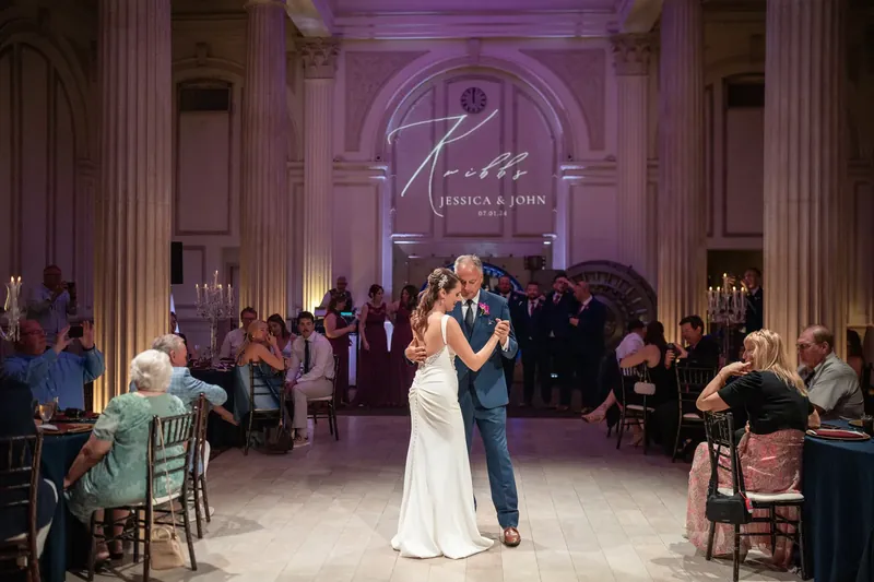 Jessica and John dance center floor while seated guests watch from both sides.