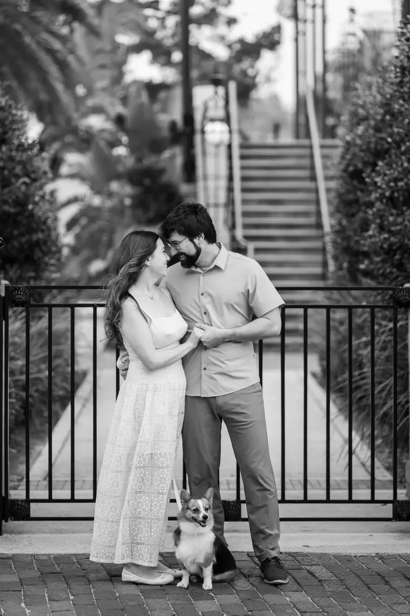 Black and white portrait of Jillian and Jason sharing an intimate moment with Bonnald at their feet