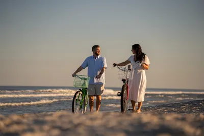 Engaged couple with their bicycles in the surf at Jacksonville Beach