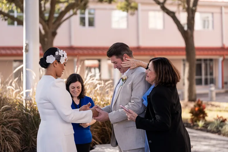 Family embracing Josh during the courthouse ceremony as the officiant smiles