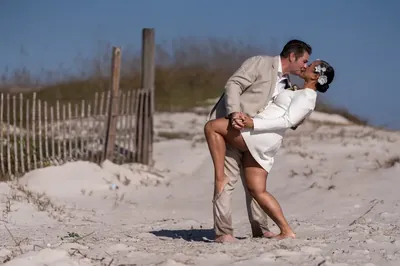 Josh dips Diane for a kiss in front of the beach dunes at Vilano Beach elopement