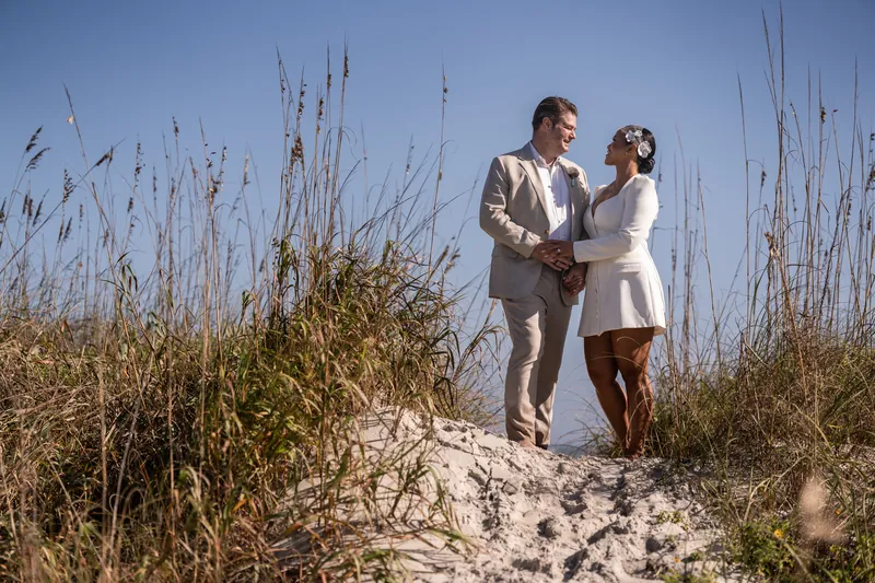 Josh and Diane stand together among the sea oats on Vilano Beach dunes