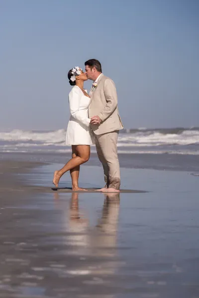 St. Augustine elopement photographer captures couple sharing a kiss on Vilano Beach with ocean waves in background