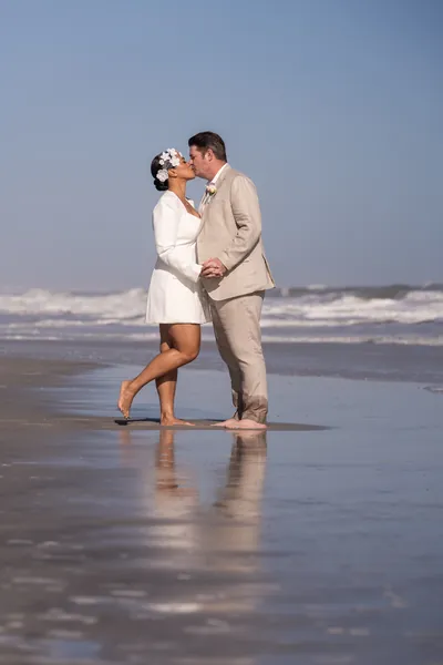 St. Augustine elopement photographer captures couple sharing a kiss on Vilano Beach with ocean waves in background