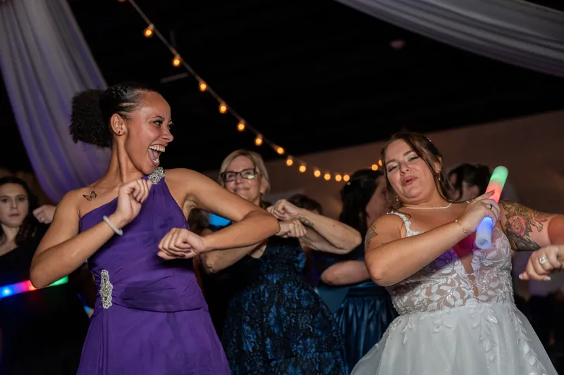 Three women dance together under string lights on the dance floor at The White Room, St. Augustine.