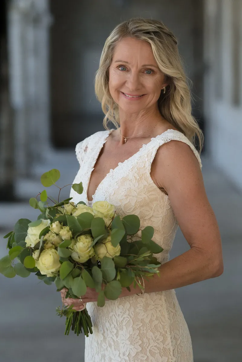 Bride portrait in ivory lace dress with yellow and white rose bouquet in Lightner Museum courtyard