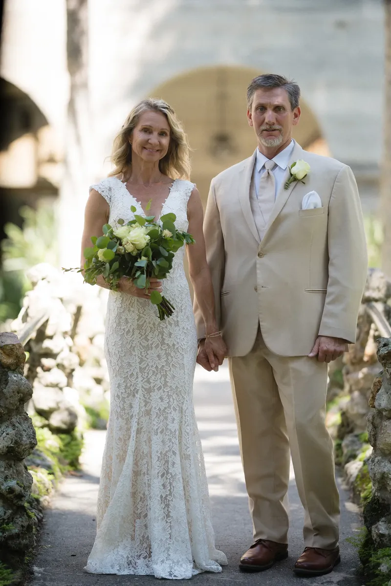 Bride and groom walking together on coquina stone pathway