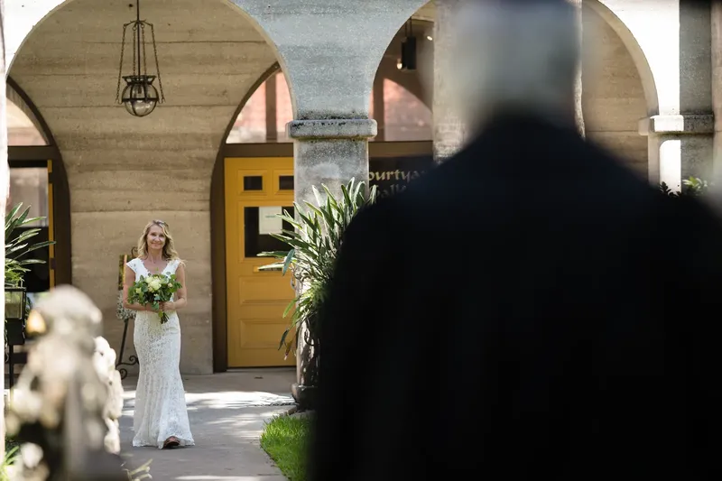 Bride walking toward ceremony with Lightner Museum arches