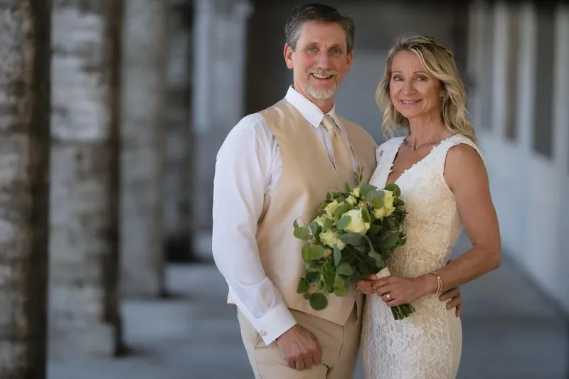 Couple portrait with groom in vest holding bride close