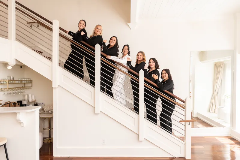 Bride and bridesmaids lined up on staircase in matching black pajamas