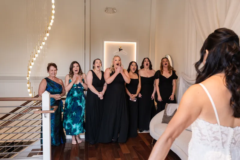Bridesmaids reacting to seeing the bride in her dress for the first time