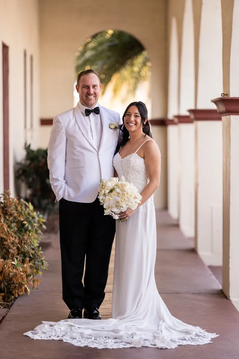 Bride and groom portrait in covered walkway with white bouquet