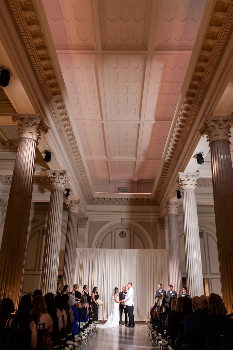 Wide ceremony shot showing Treasury's grand Corinthian columns and coffered ceiling