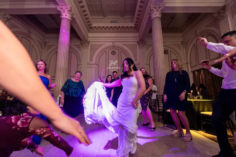 Bride dancing with guests under purple uplighting at Treasury reception