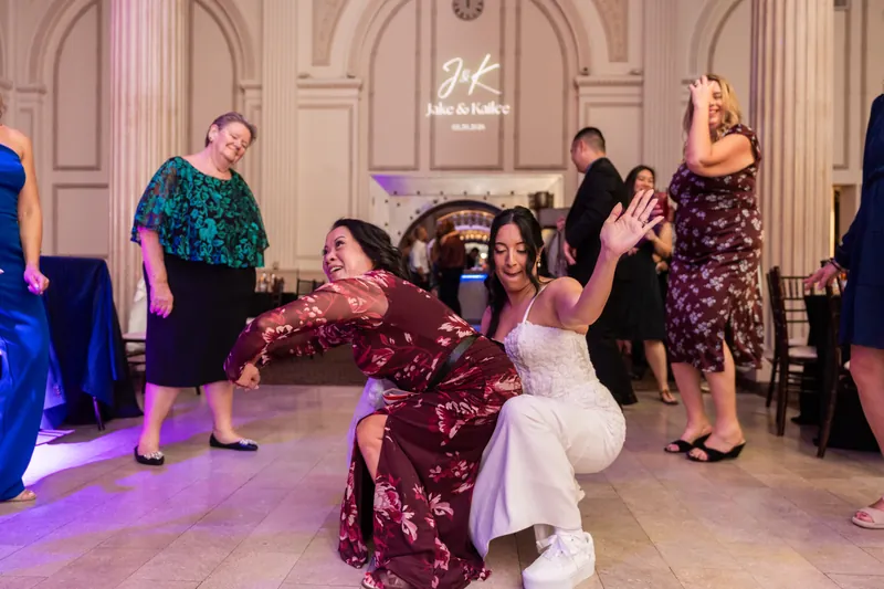 Bride and her mother dancing low to the ground on the dance floor