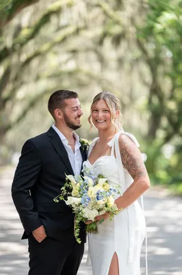 Matt and Kalsey embrace in front of the historic courthouse building, both smiling at the camera.