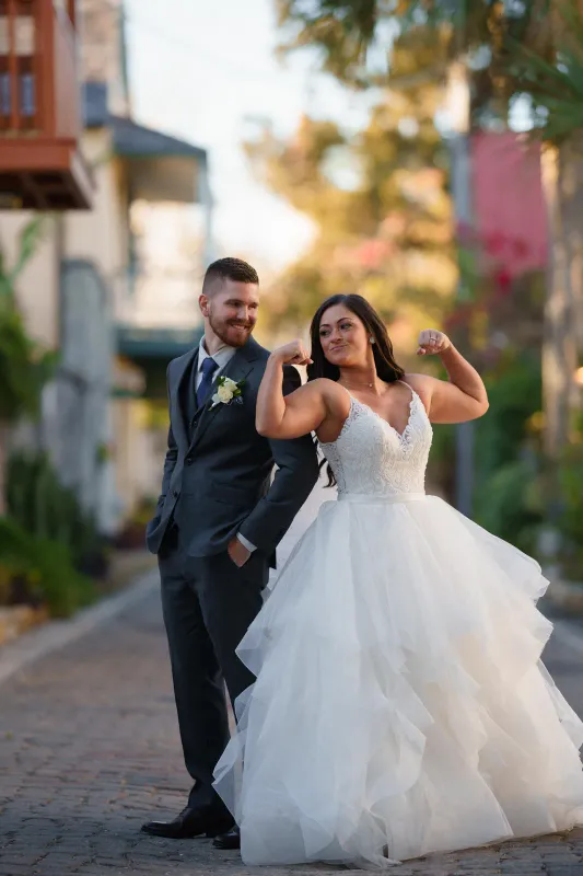 Katherine and Michael walk hand-in-hand along the water's edge at St. Augustine Bayfront during twilight.