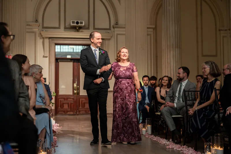 Katherine and Nathan stand together during their ceremony at The Treasury on the Plaza, with guests seated in the ornate hall