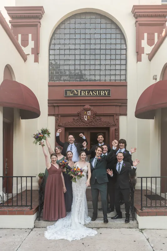 The newlyweds pose with their wedding party on the front steps of the historic St. Augustine venue.