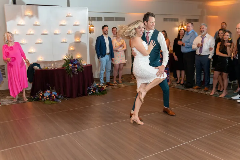 Rhett dips Kerry dramatically backward mid-dance as onlookers cheer and watch from the sidelines.