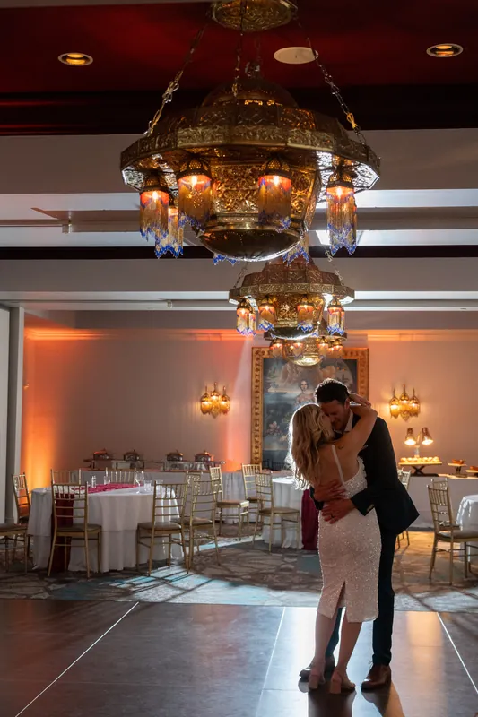 Kerry and Rhett slow dance beneath an ornate chandelier in the ballroom at Casa Monica Resort & Spa.