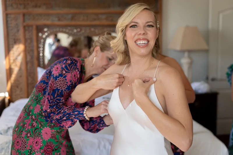 Kerry smiles as someone adjusts her white wedding dress at Casa Monica Resort & Spa.