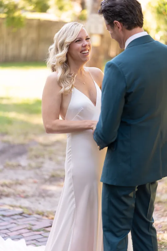 Kerry gazes at Rhett while they stand close together on the brick walkway, both dressed for their ceremony.