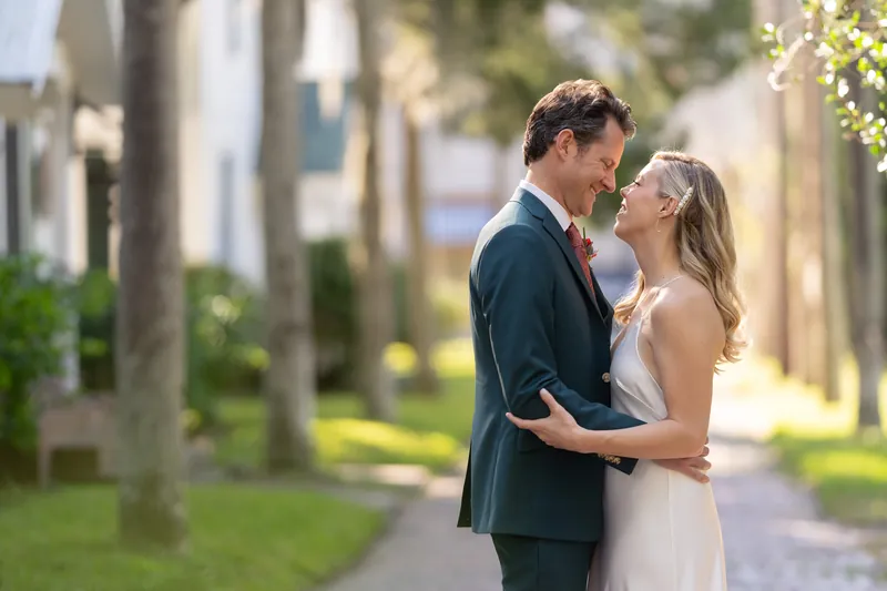 Kerry rests her head against Rhett's shoulder while his arm encircles her waist on the tree-lined pathway.