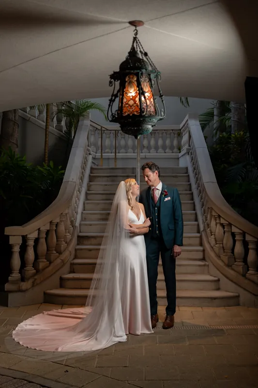 Kerry and Rhett stand together on an ornate staircase beneath a hanging lantern at the Spanish Renaissance resort.