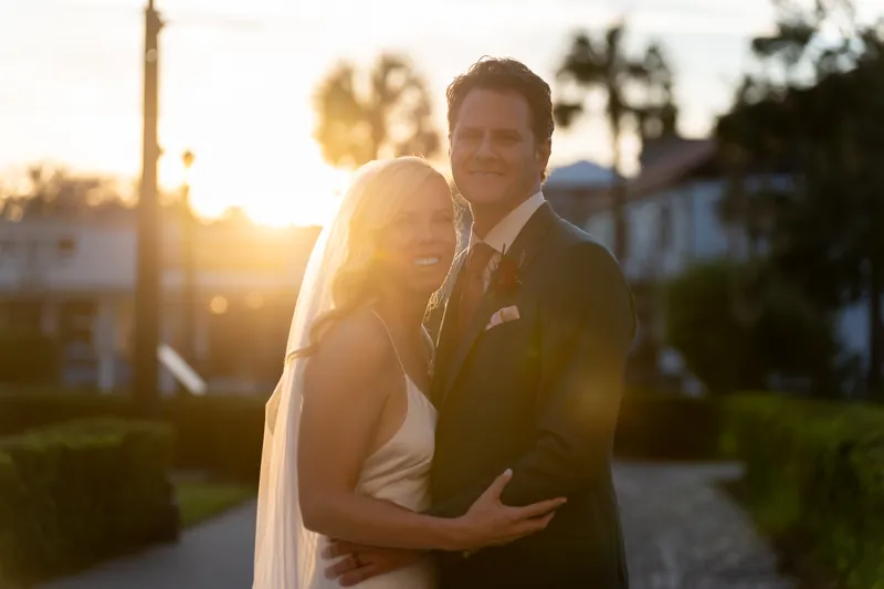 Kerry rests her head against Rhett's shoulder as golden hour light bathes them both at the venue.
