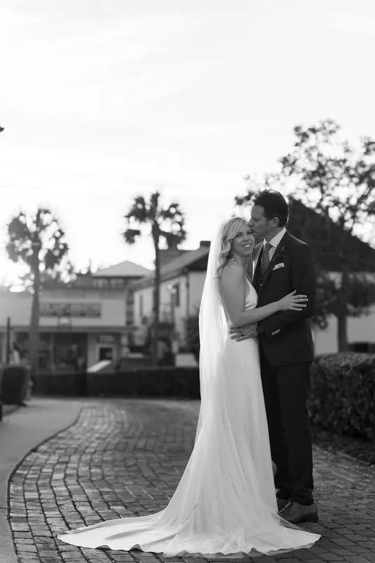 Black and white portrait of Kerry and Rhett sharing an intimate moment on the brick courtyard at Casa Monica.