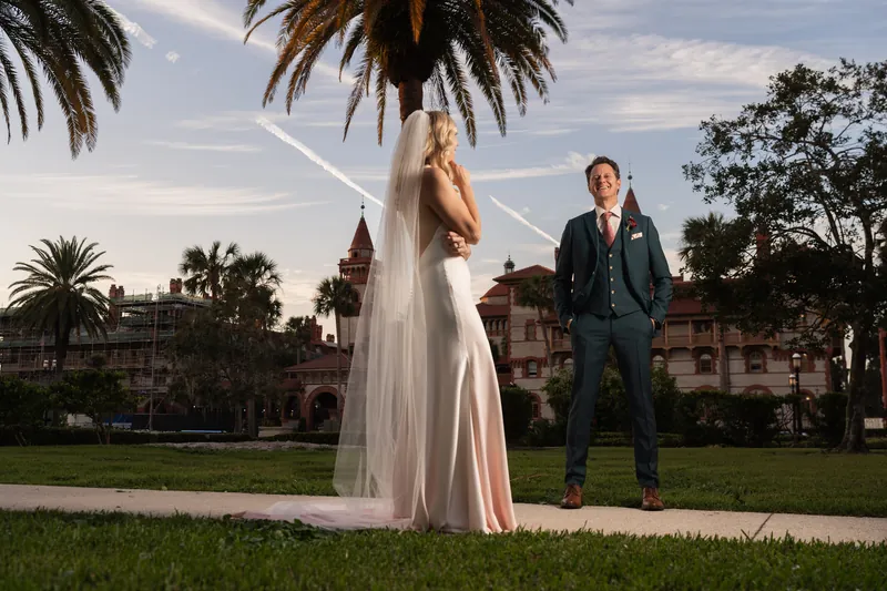 Kerry's flowing veil catches the breeze as Rhett watches from across the lawn at the resort.