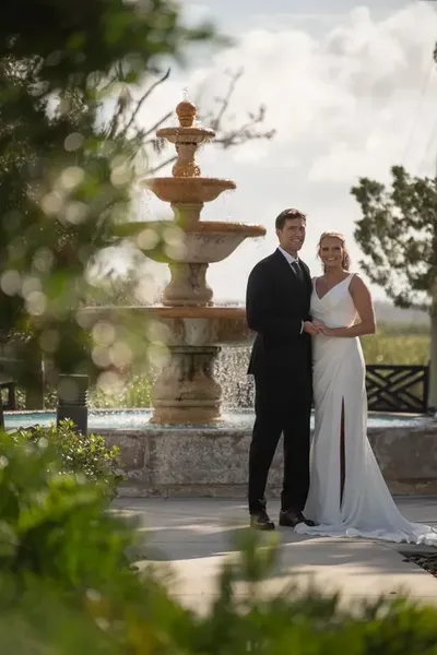 Kimberly and Landon silhouetted against golden sunset with veil flowing at River House wedding