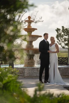 Kimberly and Landon silhouetted against golden sunset with veil flowing at River House wedding