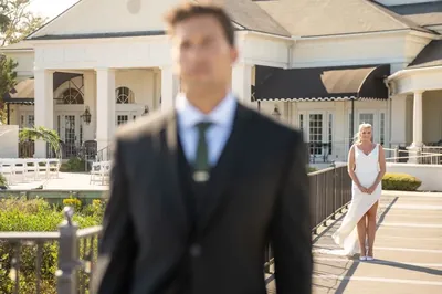 Bride approaching groom for first look on River House dock