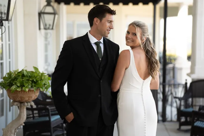 Bride and groom smiling on the veranda at River House