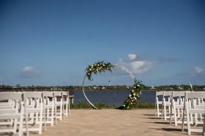 Waterfront ceremony setup with circular arch and St Augustine lighthouse at River House