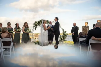 Bride and groom exchanging vows at outdoor waterfront wedding ceremony