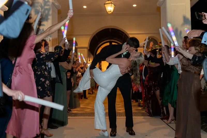 The couple dances down an indoor corridor lined with guests waving white ribbons in celebration.